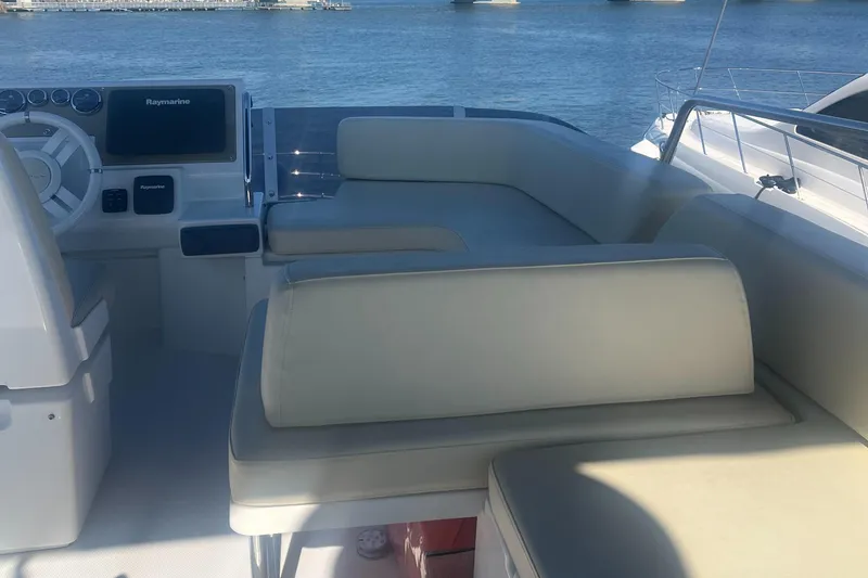 Slide: The Image of 2013 Azimut 40 Flybridge yacht interior with beige seating and navigation equipment. - 28
