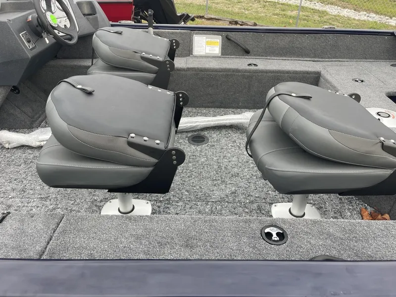 Slide: The Image of 2025 Tracker Pro Guide V-16 SC boat interior with gray seating and carpeted flooring. - 2