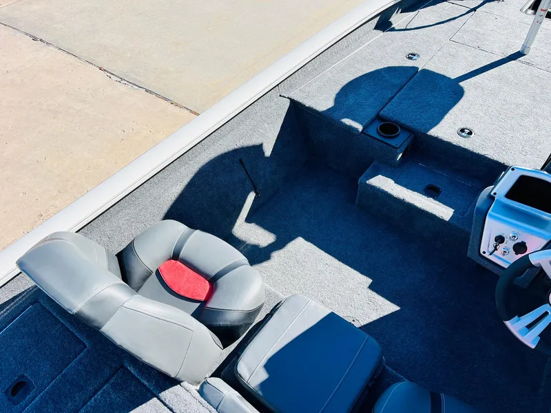 Slide: The Image of 2025 Tracker Pro Team 190 boat interior with gray seating and steering console. - 19