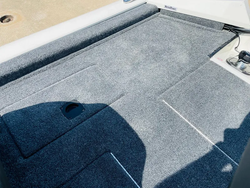 Slide: The Image of 2025 Tracker Pro Team 190 boat deck with gray carpet and storage compartments. - 26