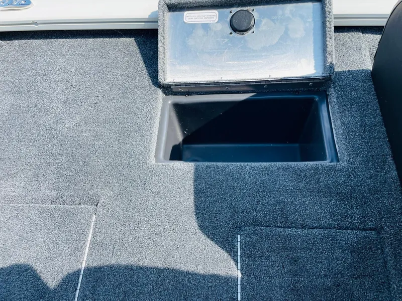 Slide: The Image of 2025 Tracker Pro Team 190 boat storage compartment with carpeted interior. - 29