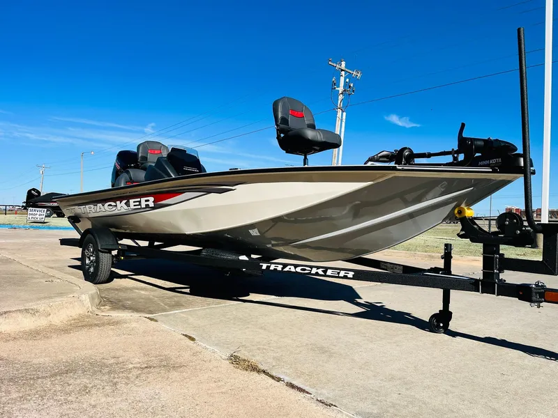 Slide: The Image of 2025 Tracker Pro Team 190 boat on trailer, parked outdoors under clear blue sky. - 3