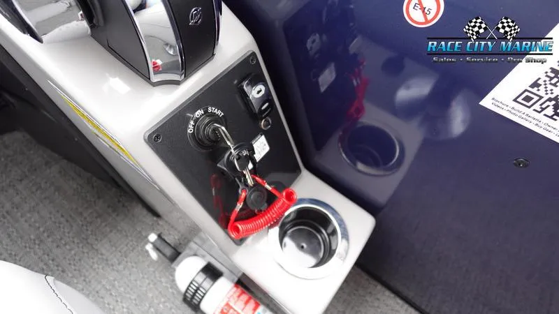 Slide: The Image of 2025 Barletta ARIA 22QC boat dashboard with ignition, cup holder, and fire extinguisher. - 23