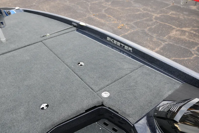 Slide: The Image of 2025 Skeeter ZXR 21 boat deck with gray carpet and storage compartments. - 18