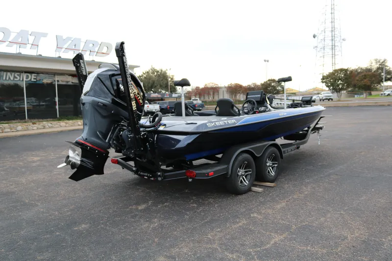 Slide: The Image of 2025 Skeeter ZXR 21 boat in parking lot, rear view, dual axle trailer. - 7