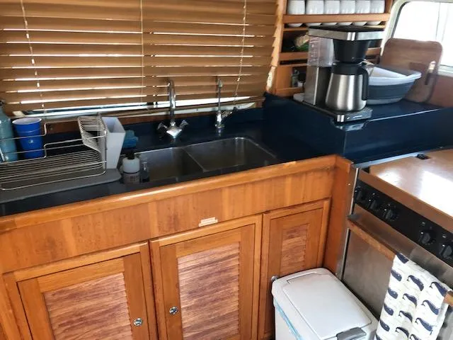 Slide: The Image of Galley kitchen in 2000 Pacific Seacraft 38T Fast Trawler with wooden cabinets and appliances. - 16