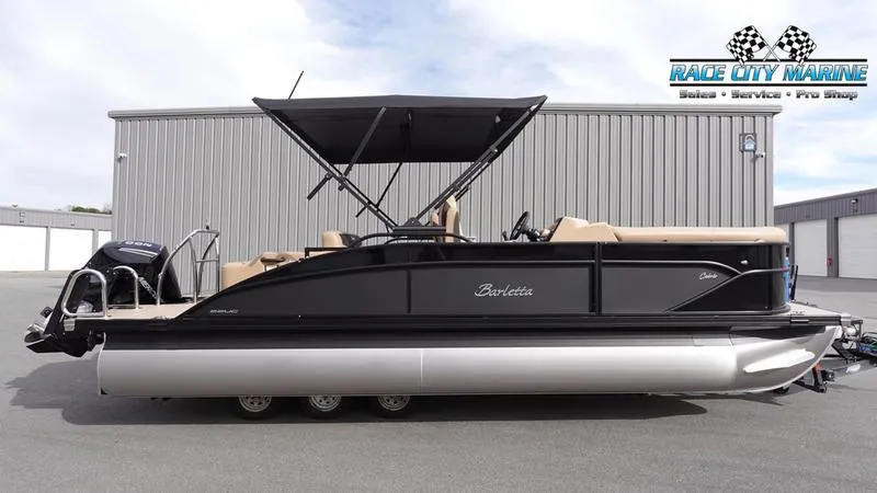 The Image of 2025 Barletta Cabrio 22UC pontoon boat with black exterior and canopy, parked outdoors. - 1
