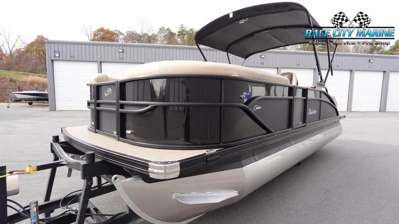 Slide: The Image of 2025 Barletta Cabrio 22UC pontoon boat with black exterior, parked at Race City Marine. - 6