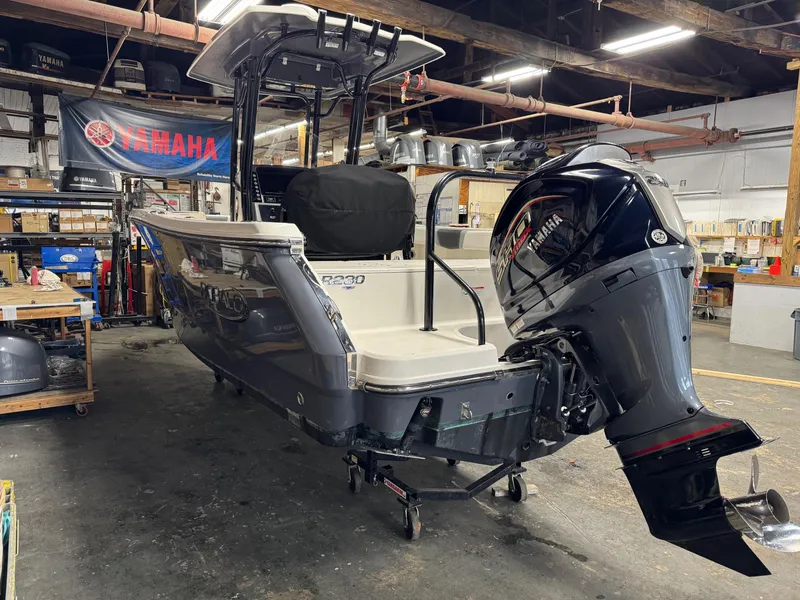 Slide: The Image of 2022 Robalo R230 Center Console boat in a workshop setting. - 3