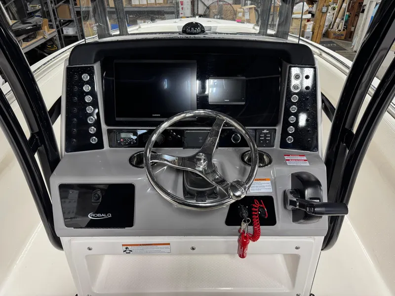 Slide: The Image of 2022 Robalo R230 Center Console dashboard with steering wheel and electronic controls. - 6