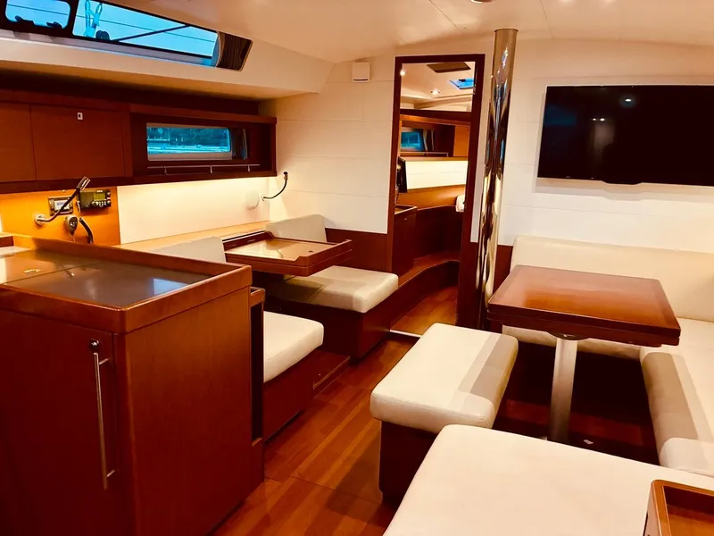 Slide: The Image of Interior of a 2017 Beneteau Oceanis 45 yacht with elegant wood finish and seating area. - 20