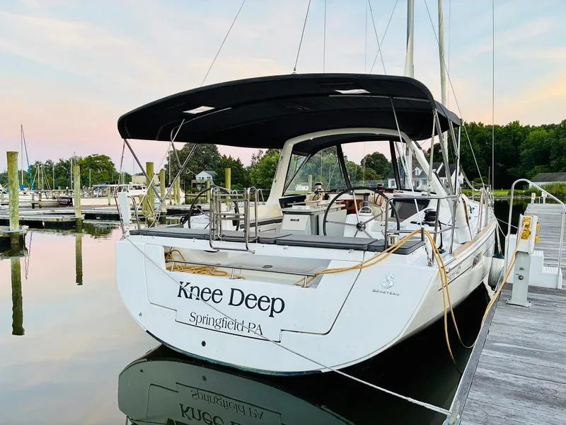 Slide: The Image of 2017 Beneteau Oceanis 45 sailboat docked at a marina, named "Knee Deep." - 3