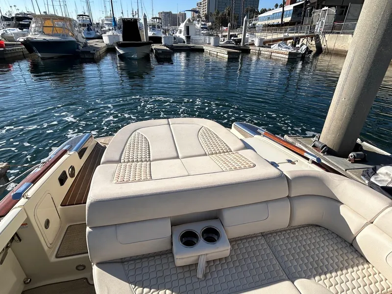 Slide: The Image of 2020 Chris-Craft 25 Launch GT boat interior at marina, featuring luxurious seating and cup holders. - 11