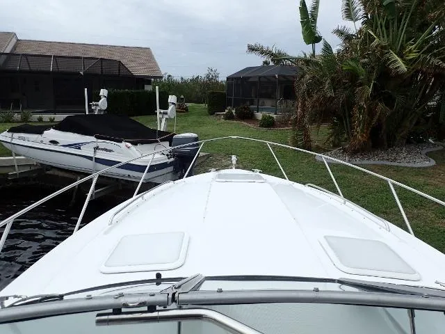 Slide: The Image of 2007 Formula 34 PC boat docked near waterfront homes and lush greenery. - 3