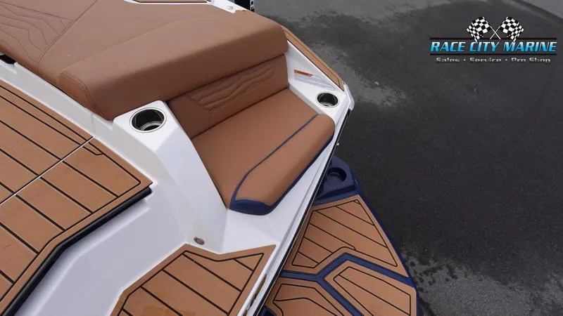 Slide: The Image of 2025 Nautique Super Air Nautique G25 boat deck with brown seating and Race City Marine logo. - 14