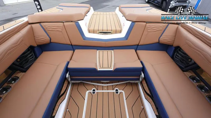 Slide: The Image of 2025 Nautique Super Air Nautique G25 interior with tan and blue seating, Race City Marine logo. - 17