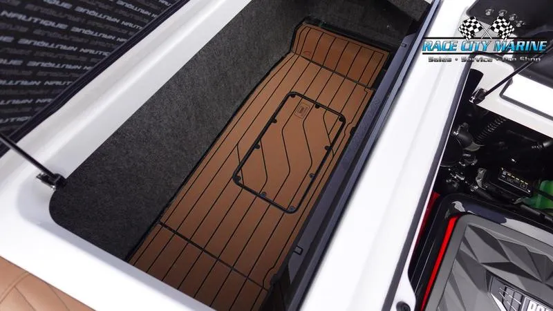 Slide: The Image of 2025 Nautique Super Air Nautique G25 storage compartment with Race City Marine branding. - 20