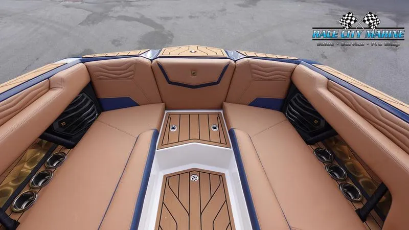 Slide: The Image of 2025 Nautique Super Air Nautique G25 boat interior with tan and blue seating. - 48
