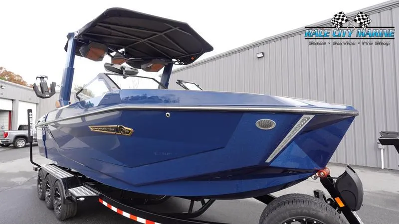 Slide: The Image of 2025 Nautique Super Air Nautique G25 boat in blue, parked on a trailer. - 5