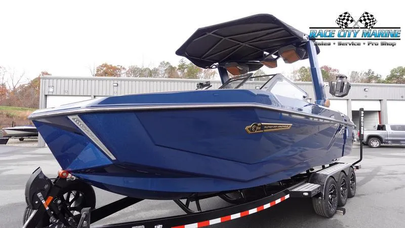 Slide: The Image of 2025 Nautique Super Air Nautique G25 boat in blue on trailer at Race City Marine. - 6