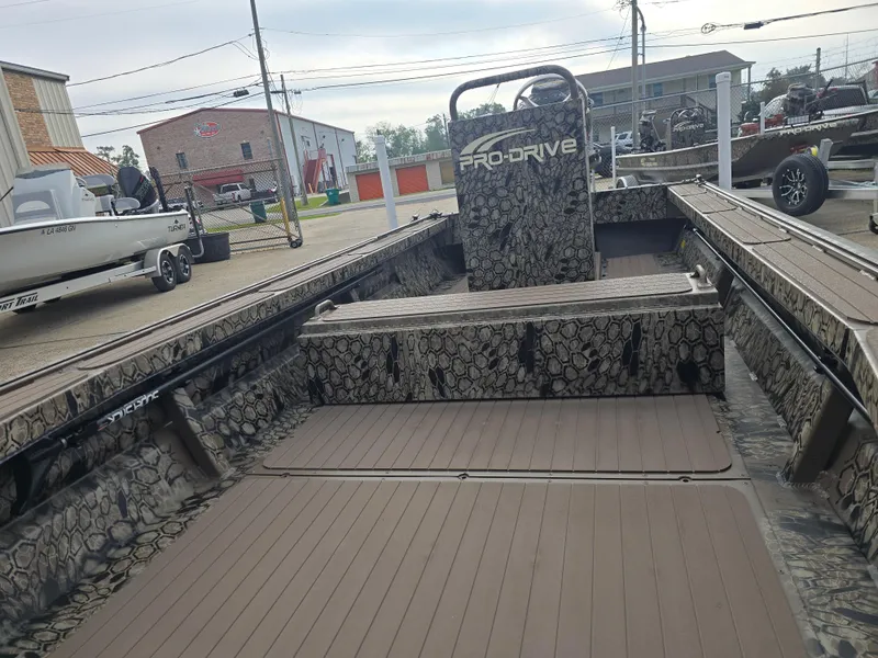 Slide: The Image of 2025 Pro-Drive 2054 X Series boat with camouflage interior, parked outdoors. - 10