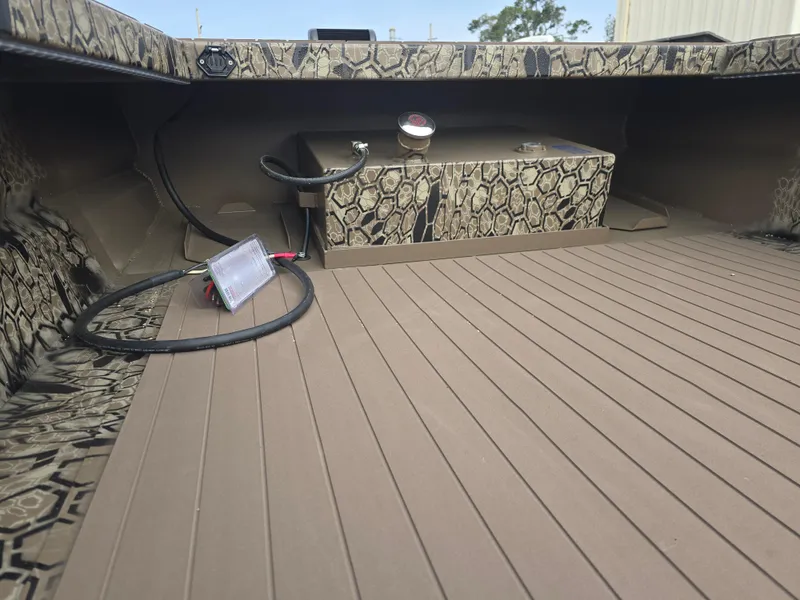 Slide: The Image of 2025 Pro-Drive 2054 X Series boat interior with camouflage design and wooden flooring. - 11