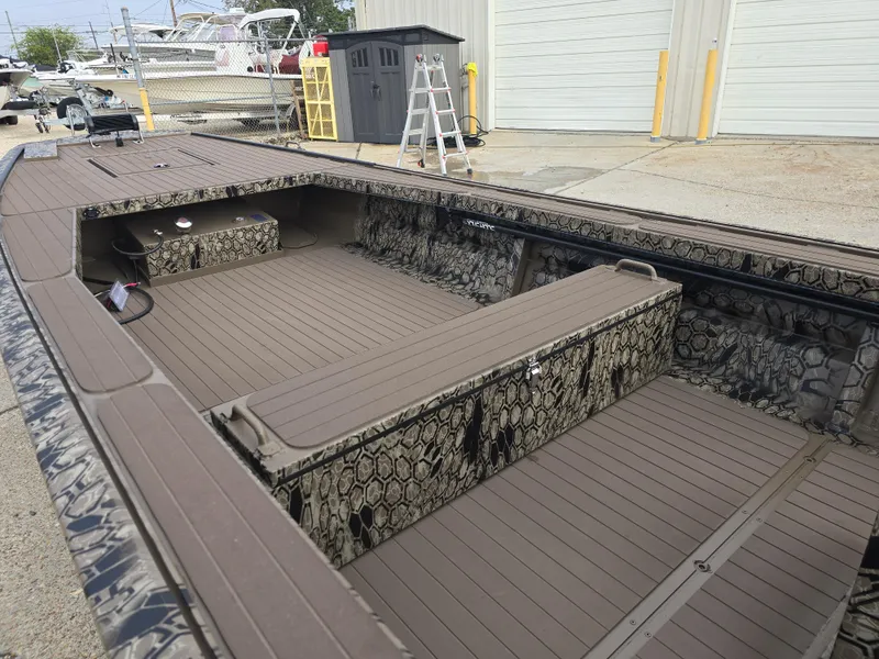 Slide: The Image of 2025 Pro-Drive 2054 X Series boat with camouflage interior, docked outdoors. - 12