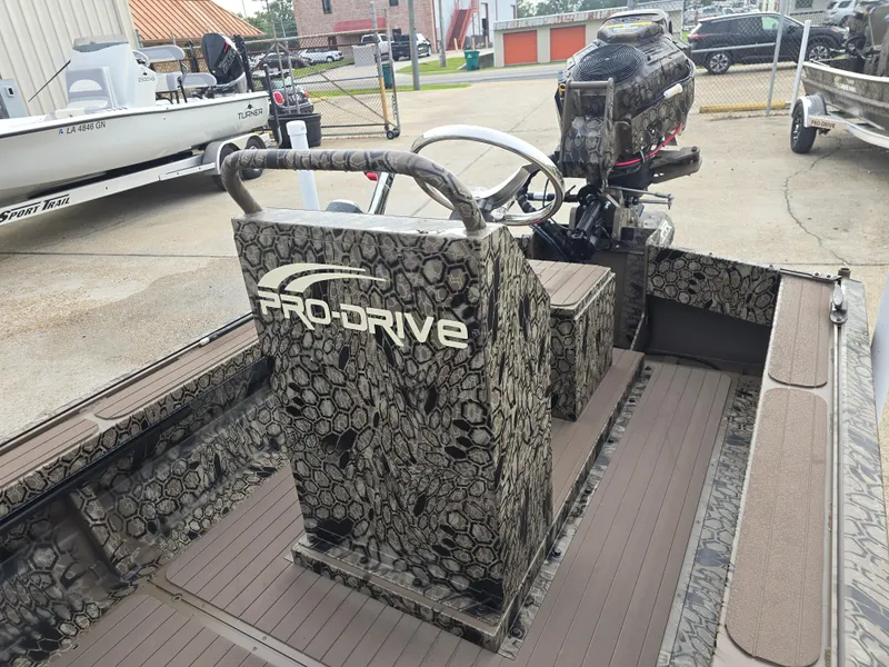 Slide: The Image of 2025 Pro-Drive 2054 X Series boat with camouflage design and steering console. - 13