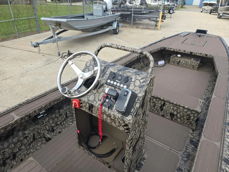 Slide: The Image of 2025 Pro-Drive 2054 X Series boat interior with camo design and steering console. - 15