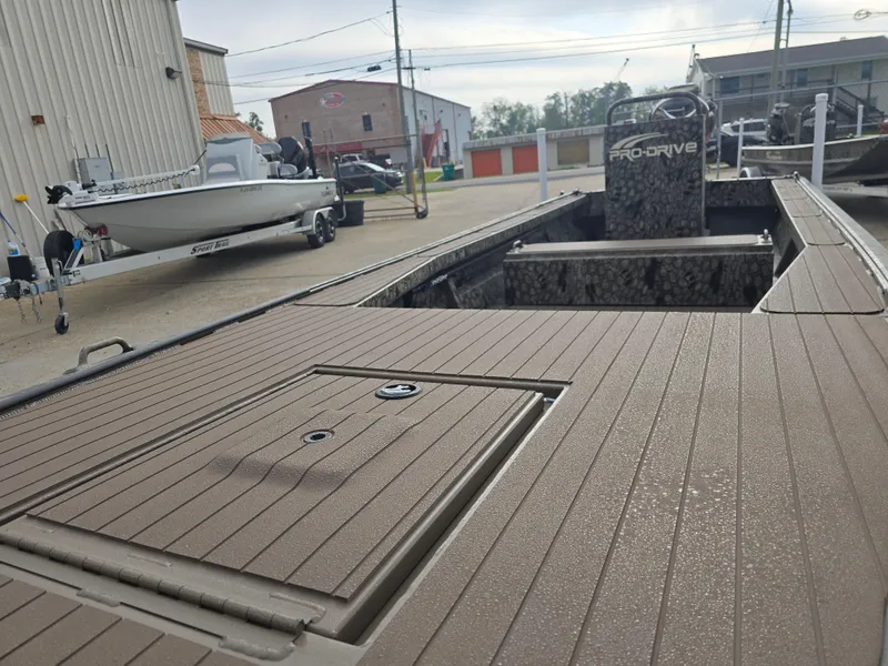 Slide: The Image of 2025 Pro-Drive 2054 X Series boat with spacious deck in a marina setting. - 9