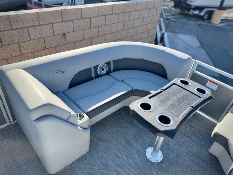 Slide: The Image of 2021 Bennington 23 LSR boat interior with gray seating and cupholder table. - 10