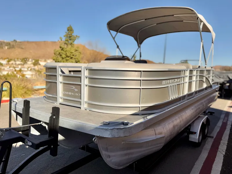 Slide: The Image of 2021 Bennington 23 LSR pontoon boat on trailer, parked outdoors. - 4