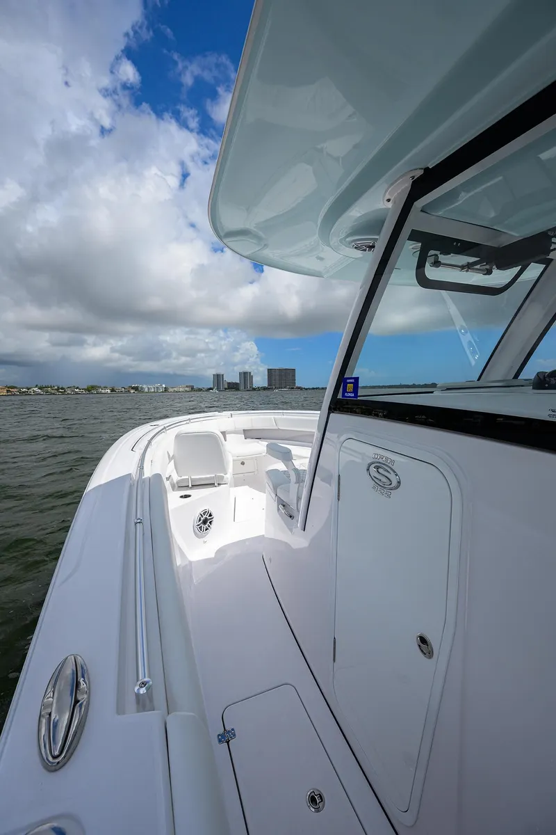 Slide: The Image of 2023 Sportsman Open 322 boat on water, showcasing sleek design and spacious deck. - 12