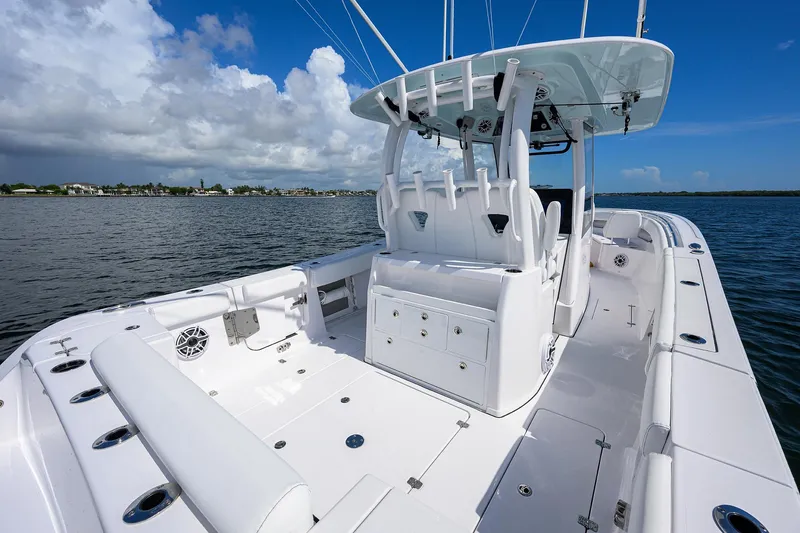 Slide: The Image of 2023 Sportsman Open 322 boat on calm water, showcasing spacious deck and seating. - 16