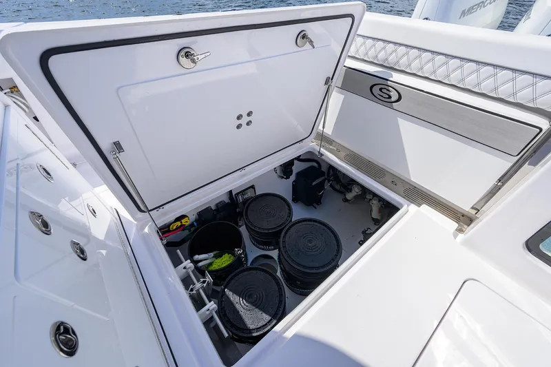 Slide: The Image of 2023 Sportsman Open 322 storage compartment with organized equipment and supplies. - 21