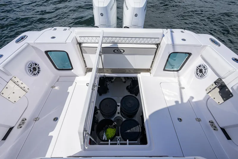 Slide: The Image of 2023 Sportsman Open 322 boat deck with storage compartments and twin engines. - 22