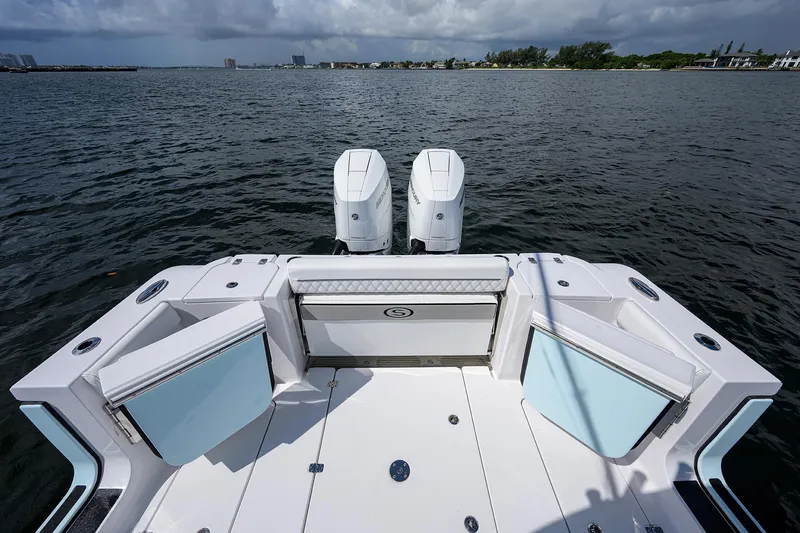 Slide: The Image of 2023 Sportsman Open 322 boat with dual engines on a calm water backdrop. - 25