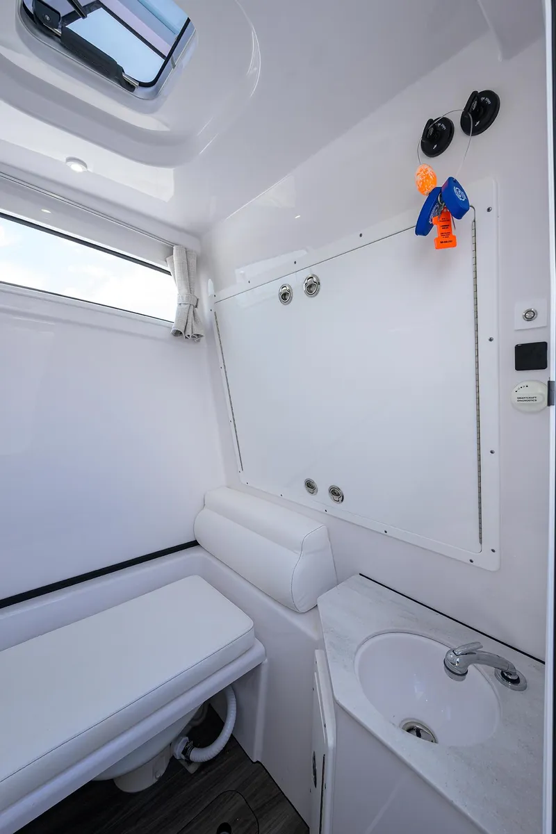 Slide: The Image of 2023 Sportsman Open 322 boat bathroom with white interior and compact sink. - 28