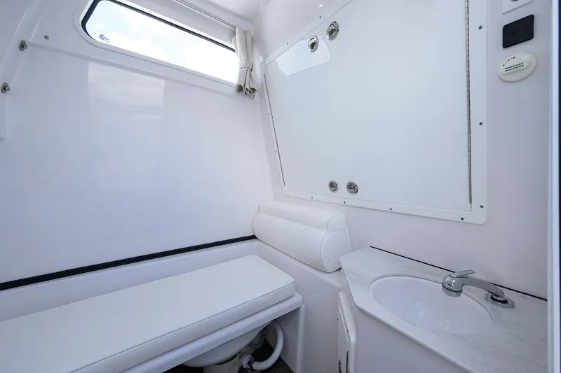 Slide: The Image of 2023 Sportsman Open 322 boat interior with white bathroom and sink. - 29