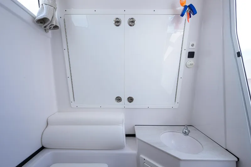 Slide: The Image of 2023 Sportsman Open 322 boat interior with white seating and compact sink area. - 30