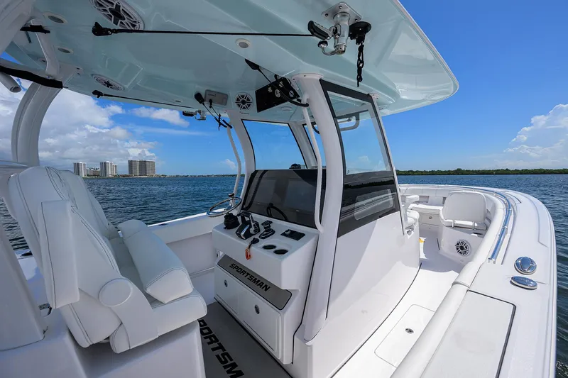 Slide: The Image of 2023 Sportsman Open 322 boat interior with helm, white seating, and ocean view. - 32