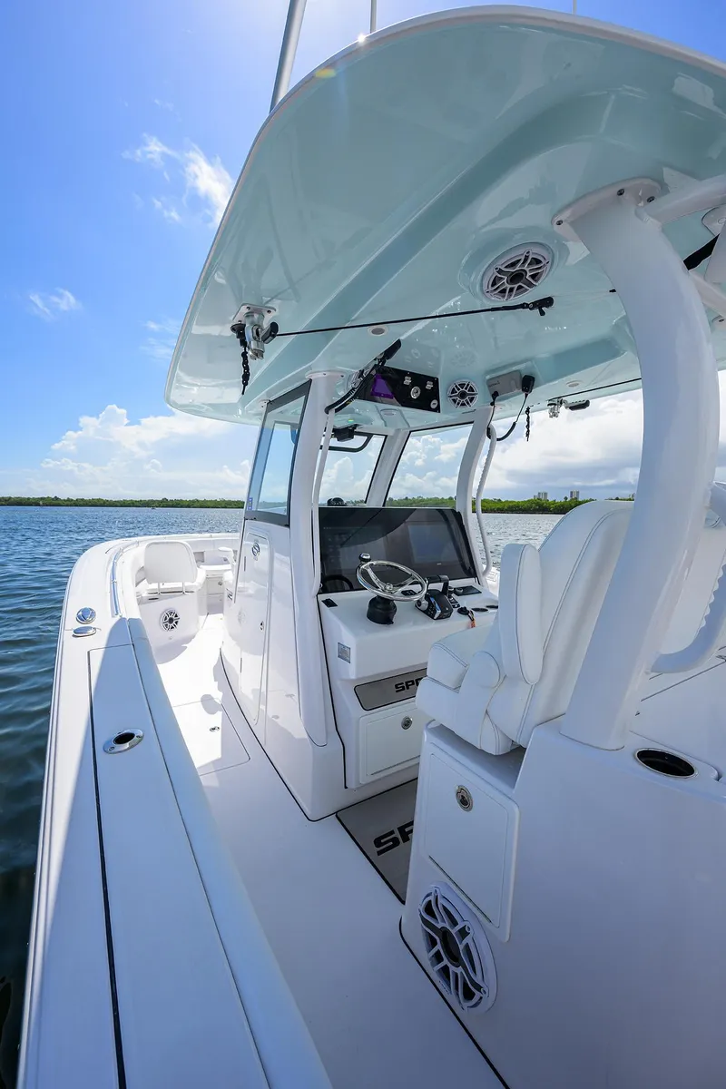 Slide: The Image of 2023 Sportsman Open 322 boat interior with modern helm and seating on a sunny day. - 37