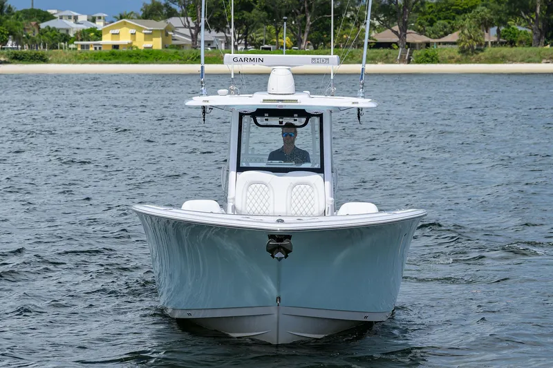 Slide: The Image of 2023 Sportsman Open 322 boat on water, front view, with coastal background. - 4
