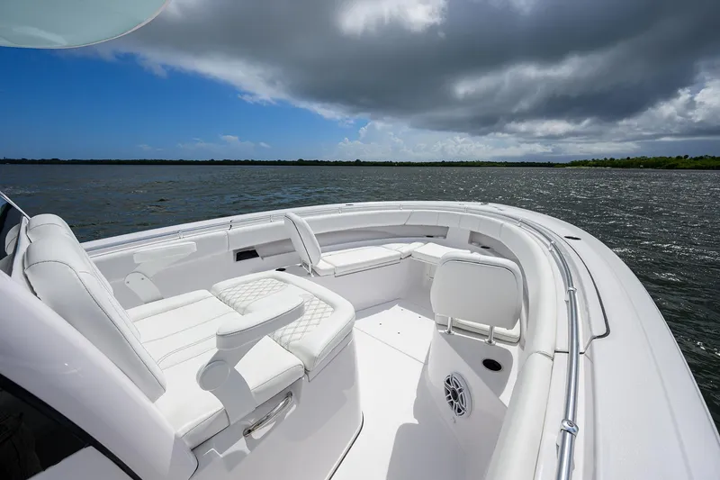Slide: The Image of 2023 Sportsman Open 322 boat on water, featuring sleek white seating and modern design. - 6