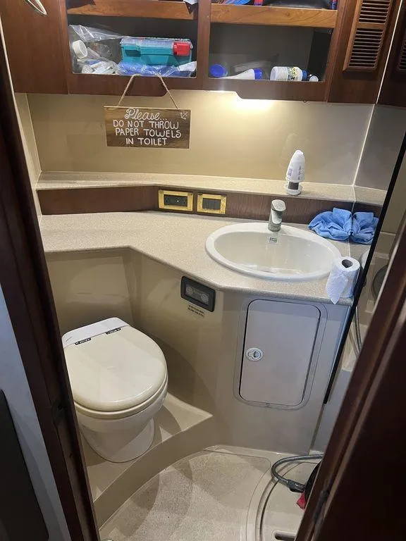 Slide: The Image of 2006 Rampage 38 Express boat bathroom with sink, toilet, and storage shelves. - 17