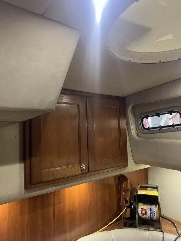 Slide: The Image of Interior cabin of 2006 Rampage 38 Express boat with wooden cabinets and porthole. - 22