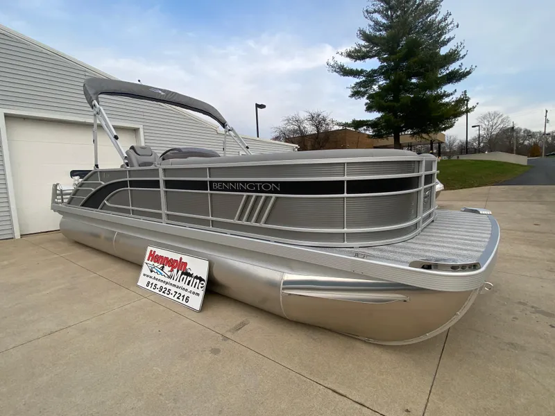 Slide: The Image of 2025 Bennington 23 LSB pontoon boat parked on concrete driveway. - 1