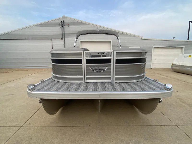 Slide: The Image of 2025 Bennington 23 LSB pontoon boat in a marina setting. - 2