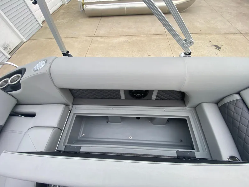 Slide: The Image of 2025 Bennington 23 LSB boat interior with open storage compartment and cup holders. - 25