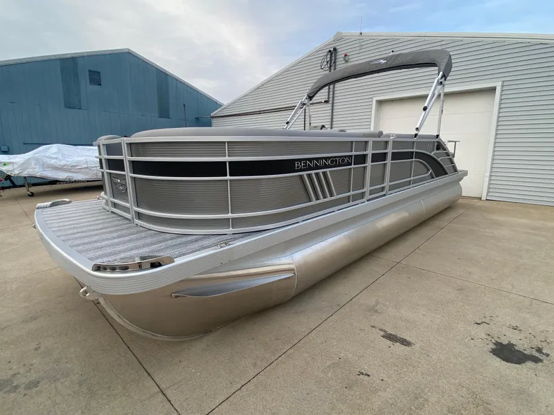 Slide: The Image of 2025 Bennington 23 LSB pontoon boat in a driveway, showcasing sleek design and modern features. - 3